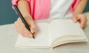 teacher writing in notebook