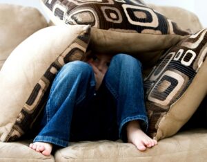 someone hiding under several pillows