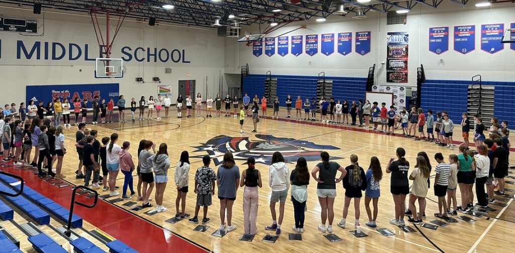 IMPACT! Middle School Summer Band Camp students standing in circle