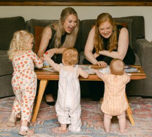 Annie Ray and Alexandra Blaine in living room with their daughters