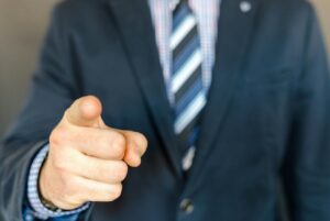 man holding hand up with index finger pointing forward