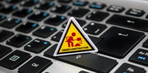 small "under construction" sign sitting atop computer keyboard