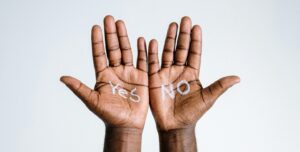 two hands help up with "Yes" and "No" written on the palms