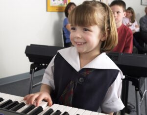 female student playing keyboard with one hand