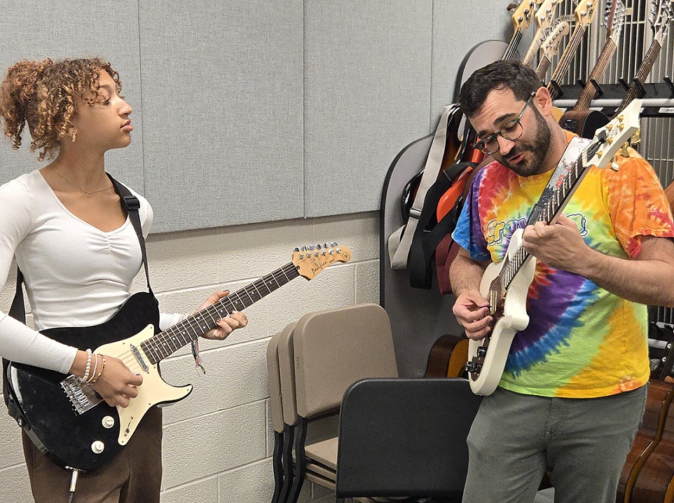 Adam Odenwelder with a guitar student