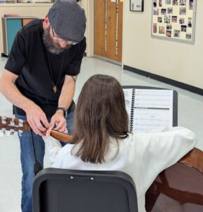 Jacob Abbot helping student on guitar
