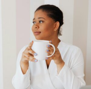 woman holding coffee mug and looking off to the side