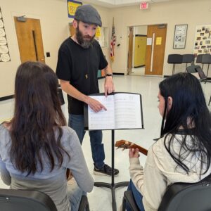Jacob Abbott helping students on the ukulele