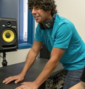 Nick Popovich in NVAA studio wearing headphones