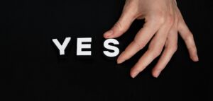 close up of hand arranging the word YES on a bulletin board