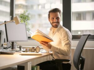 happy teacher smiling and sitting at his desk 