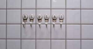 hooks on tiles that spell out "REPEAT"