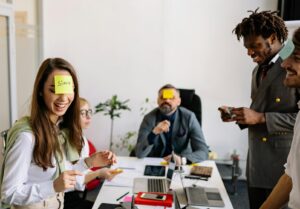 group of people with sticky notes on their foreheads, playing an ice breaker 