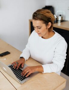 woman sitting typing on laptop 