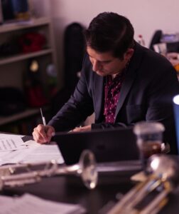 music educator sitting at desk and writing notes 
