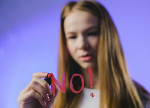 woman writing "No" in lipstick on window 