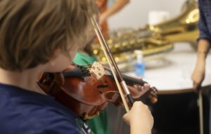 child exploring the violin at the Instrument Petting Zoo during Meet the Opera workshop