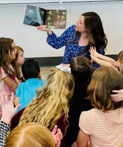 Dr. Cassandra Eisenreich reading and holding up book for preschoolers to see 