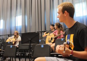 instructor with guitar students