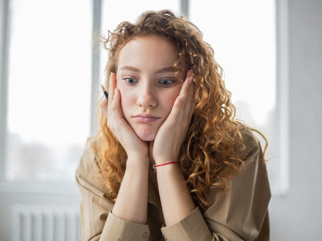 overwhelmed student holding face in her hands