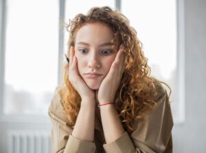 overwhelmed student holding face in her hands