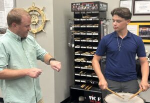 band director instructs student on snare drum