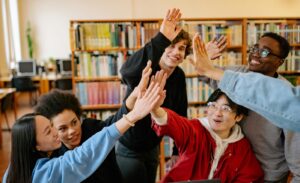 happy group of students high-fiving
