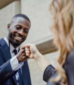 man and woman co-workers fist-bumping