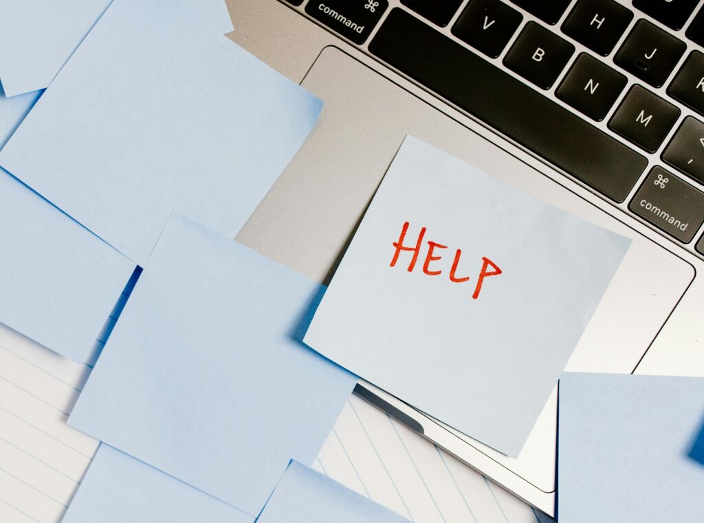 open laptop with sticky note that says "help" on it