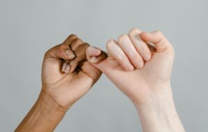 two hands with pinkies clasped
