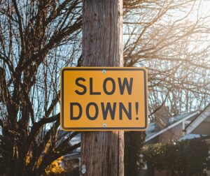 Slow Down road sign hung on a tree