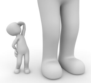 small clay figure looking up at a giant figure