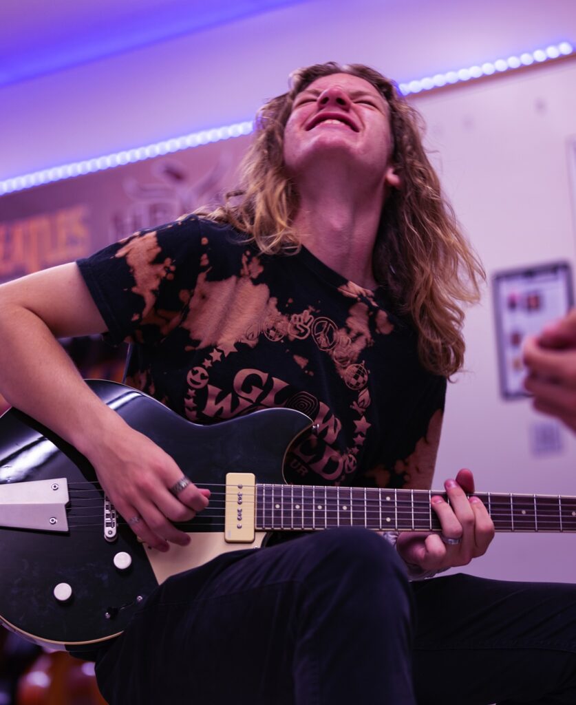 student playing electric guitar