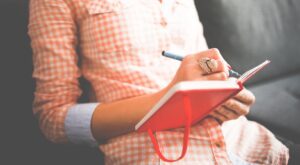 woman taking notes in a notebook