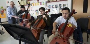 three cello students and volunteer during a Crescendo Orchestra class