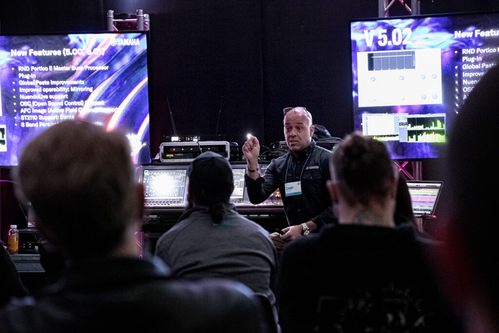 man doing lecture with audio mixer in background