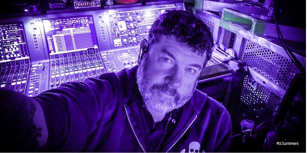 man taking a selfie with audio mixer in background