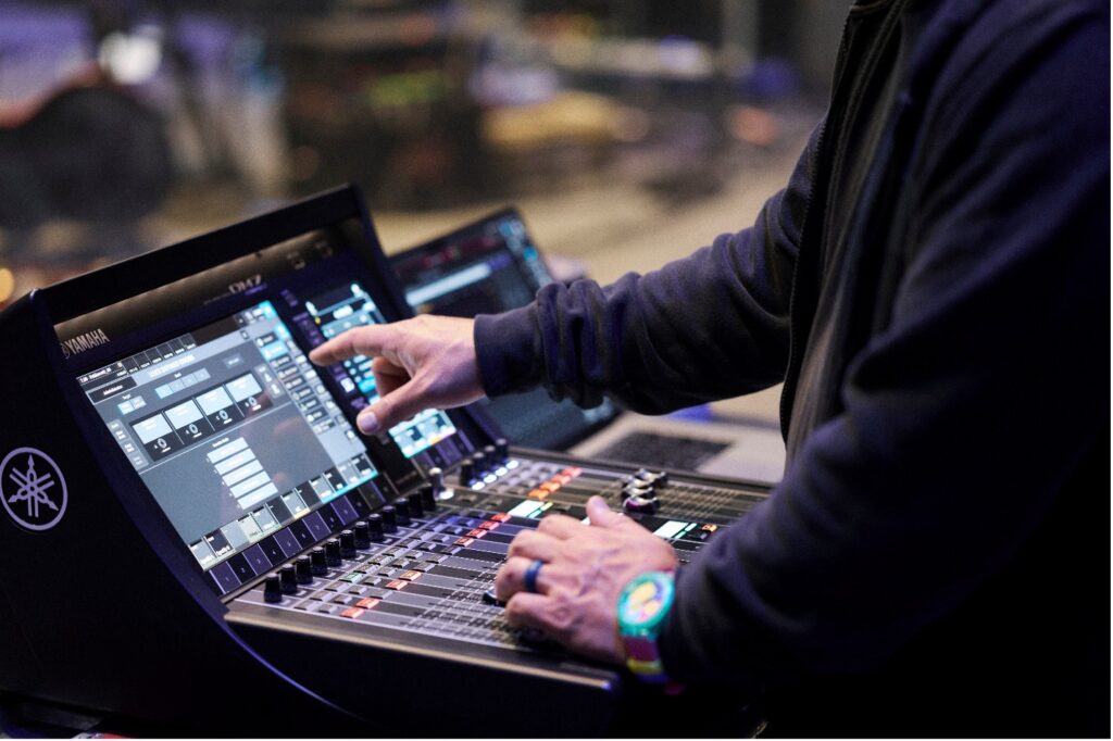 man pressing screen on audio mixer