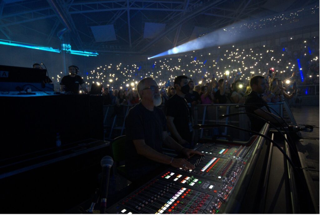 man in front of an audio mixer in darkness