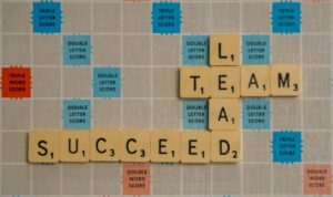 letter tiles that spell out "lead," "team" and "succeed" 