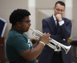 Dr. Aaron Witek observing a student playing the trumet