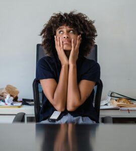 overwhelmed teacher sitting with hands on her face