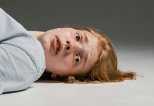 female lying on the ground with panicked look