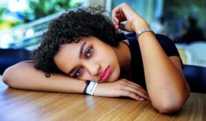 female student looking sad as she rests head on desk