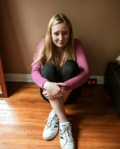 frightened student sitting on the ground