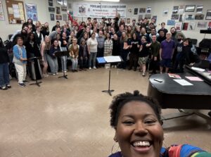 Coty Raven Morris in foreground with her choir behind her during rehearsal