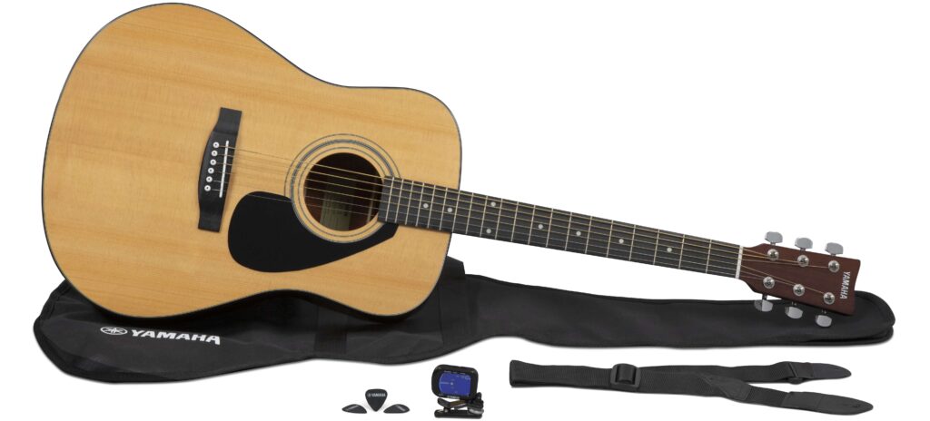 An acoustic guitar with soft case, guitar strap, tuner and picks.