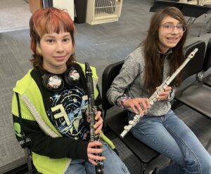 student holding clarinet and student holding flute