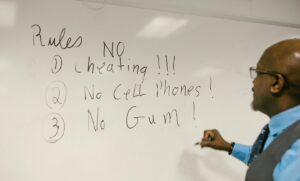 teacher writes class rules on whiteboard