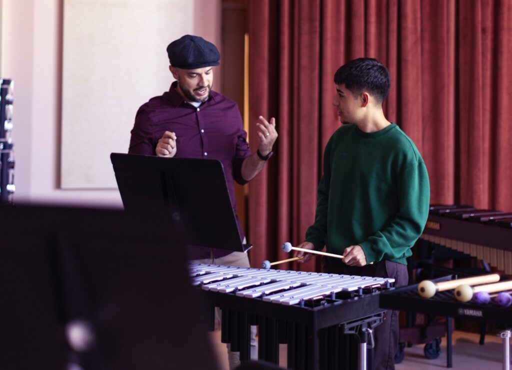 music educator talking to percussion student